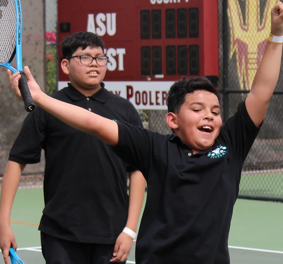 Photo of two boys cheering at the tennis event of Pass Kids.